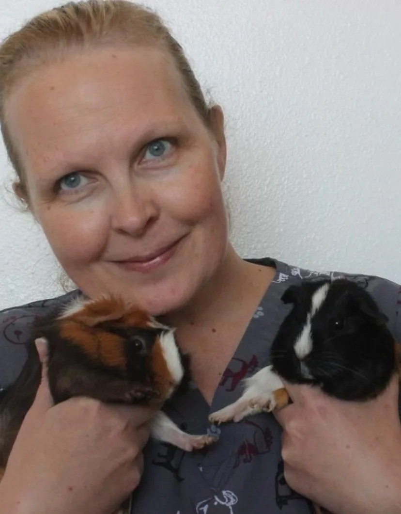 Emma Scott holding a pair of guinea pigs.